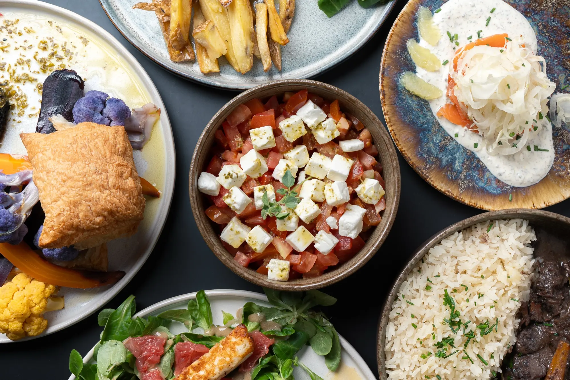 La table de Cocorico vue du dessus : salades, riz, frites et plats à partager