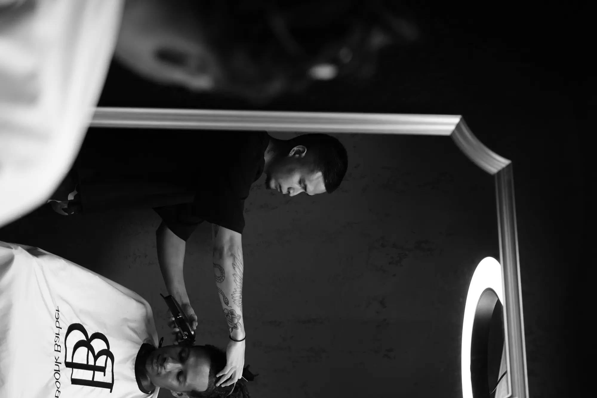 Barbier au travail dans son salon, reportage en noir et blanc