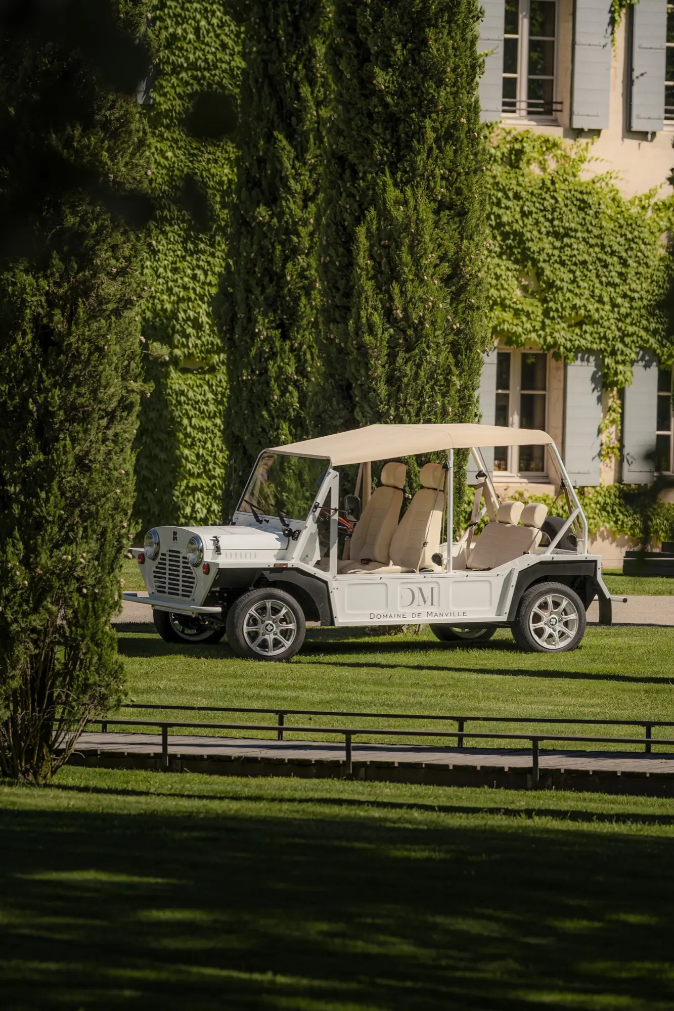 Voiturette devant la façade végétalisée d'un domaine en Provence